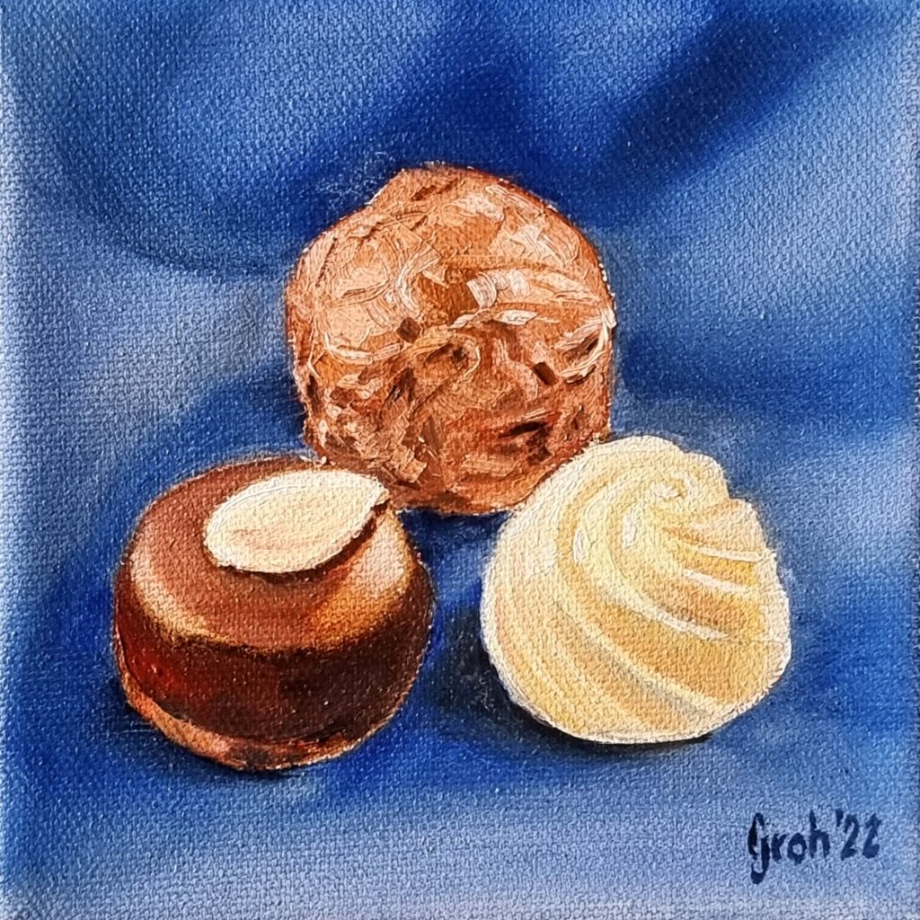 Drei Pralinen auf blauer Decke