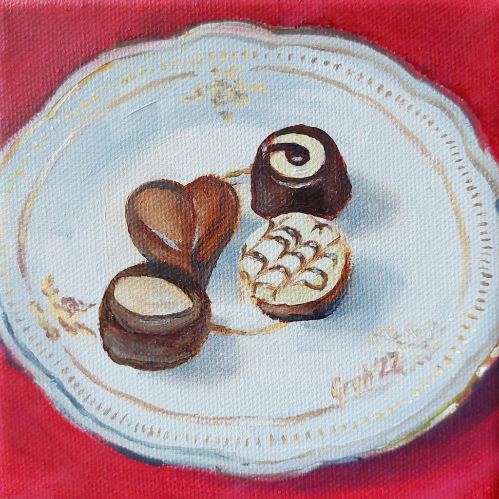 Vier Pralinen auf Porzellanteller